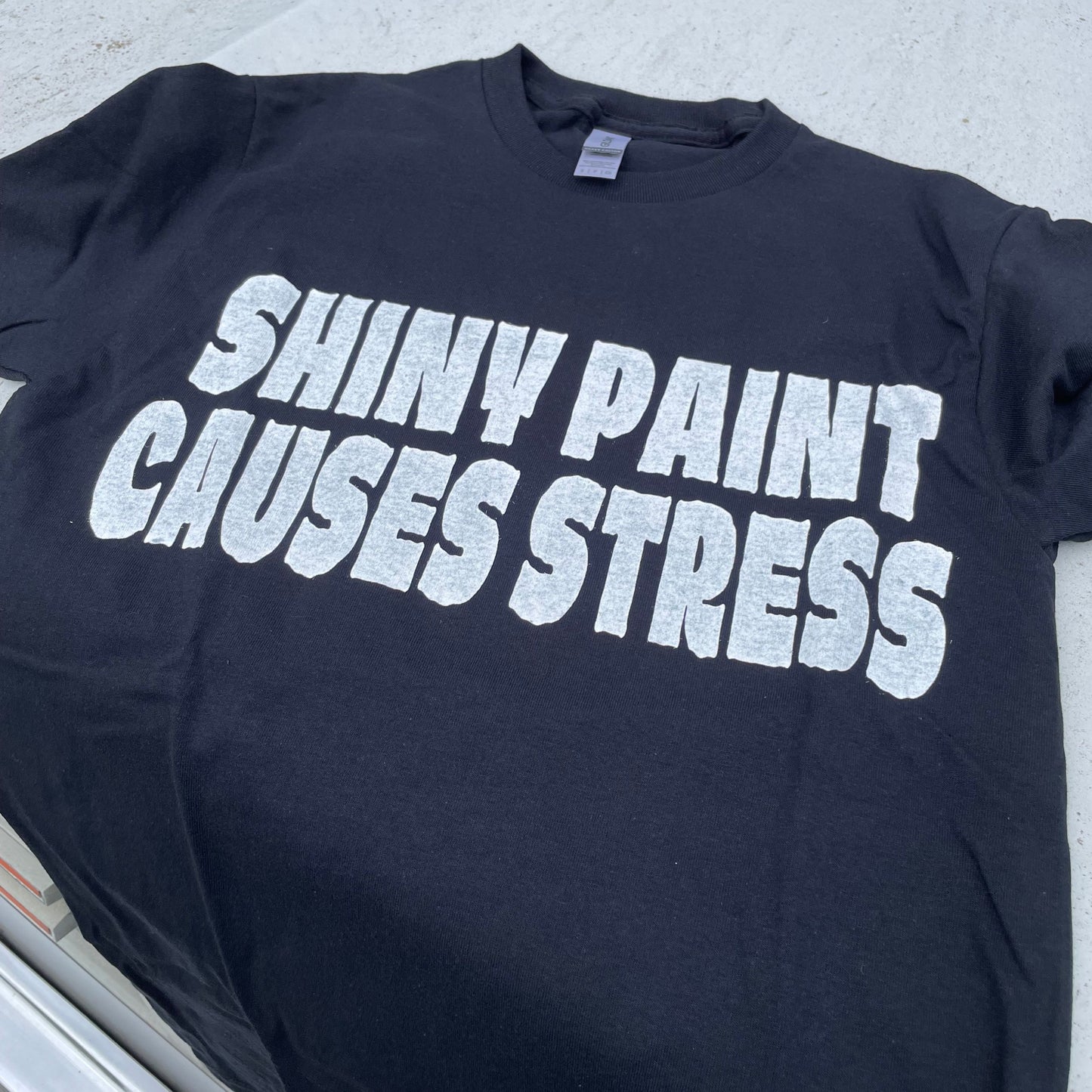Shiny Paint Causes Stress t-shirt laid on the hood of a Chevy C10 truck — the original patina hot rod tee — Rod Shop Collective — Louisville, Kentucky