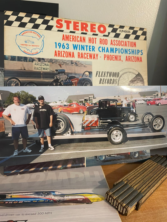 Photo of a man and his son standing beside their 1963 Logghe Stamping Co front engine dragster at the NSRA Street Rod Nationals