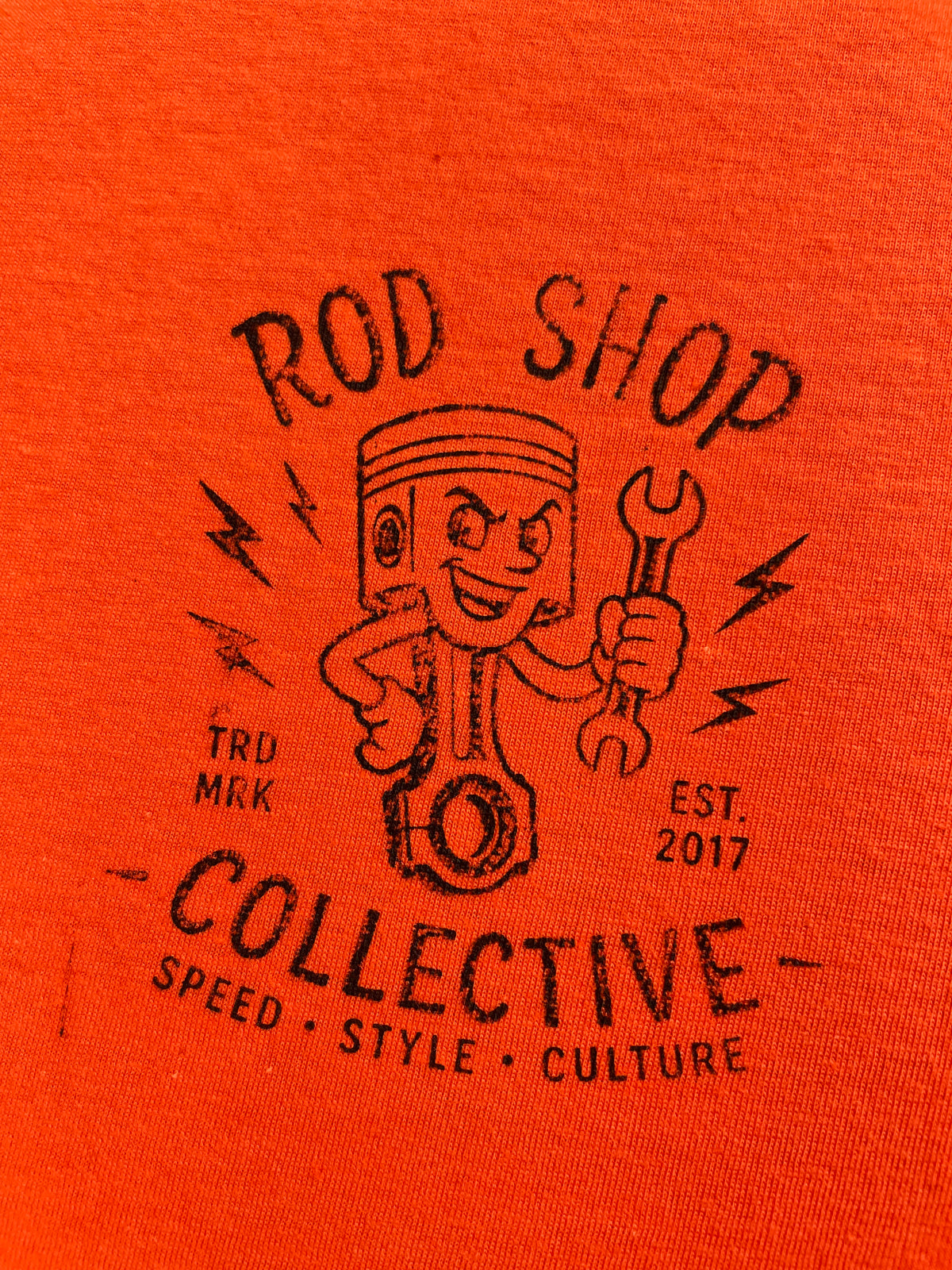 Hand-stamped Rod Shop Collective piston logo on the front pocket of the 2026 Halloween tee, stamped one at a time, Rod Shop Collective, Louisville KY