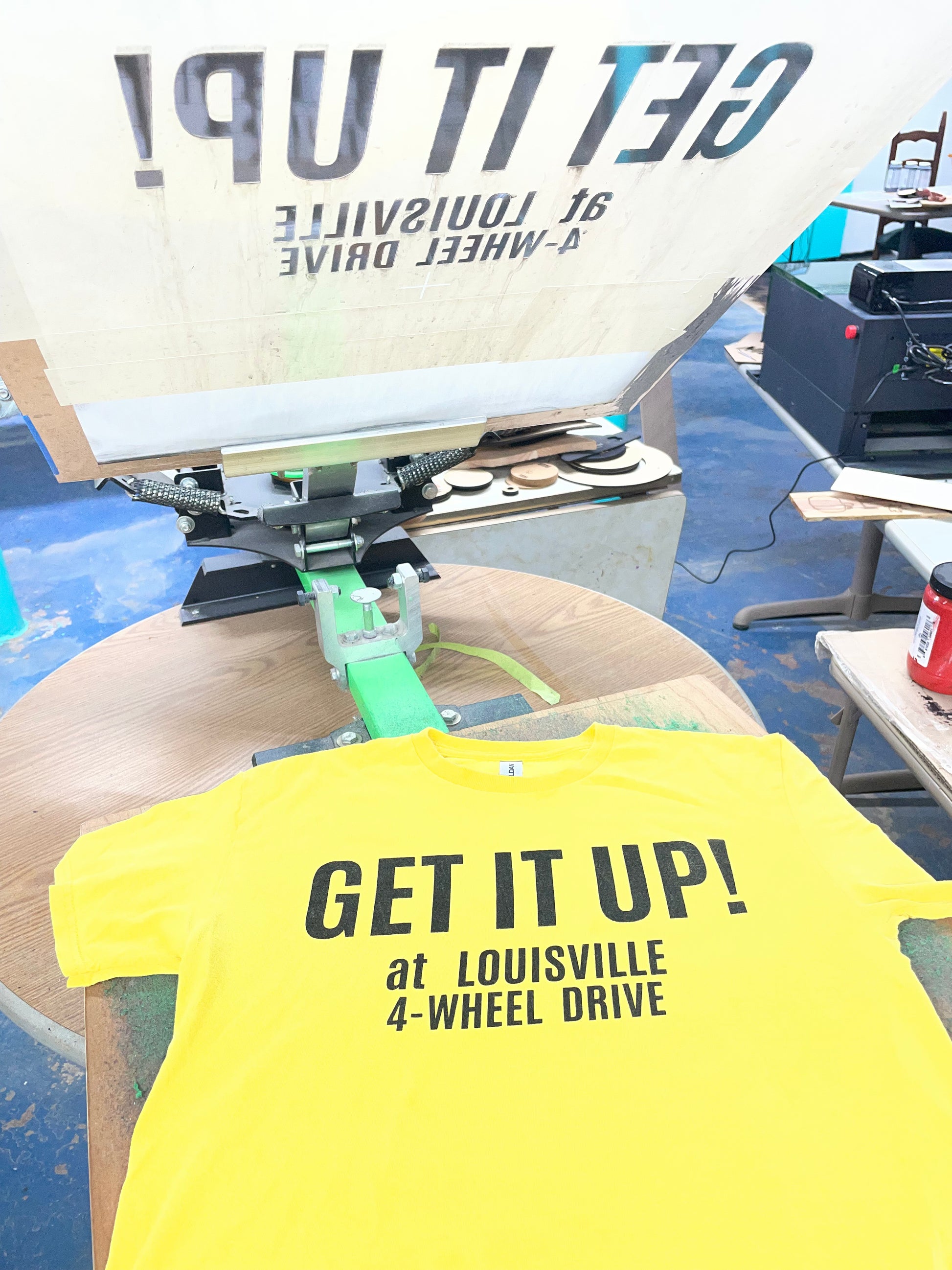 Get It Up At Louisville 4-Wheel Drive t-shirt graphic detail — black screen print on yellow — tribute to the historic Louisville Kentucky truck shop — Rod Shop Collective