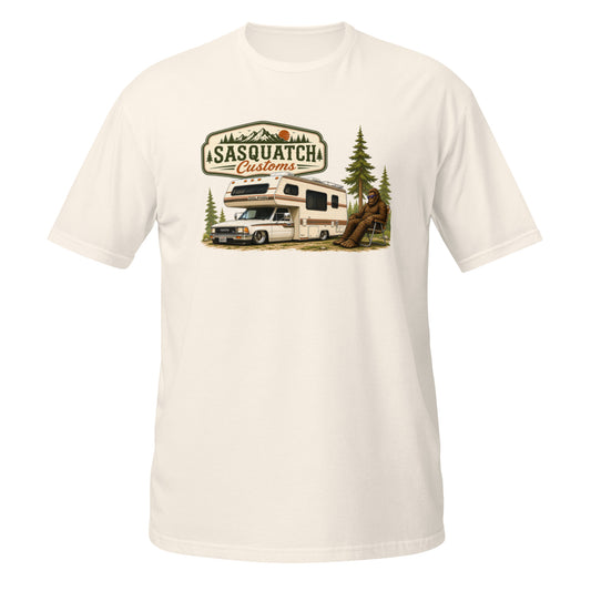Sasquatch Customs Camping Series t-shirt — Bigfoot sitting in a vintage lawn chair next to a 1989 Toyota mini truck camper in a pine forest — funny Sasquatch camping tee on natural — Rod Shop Collective
