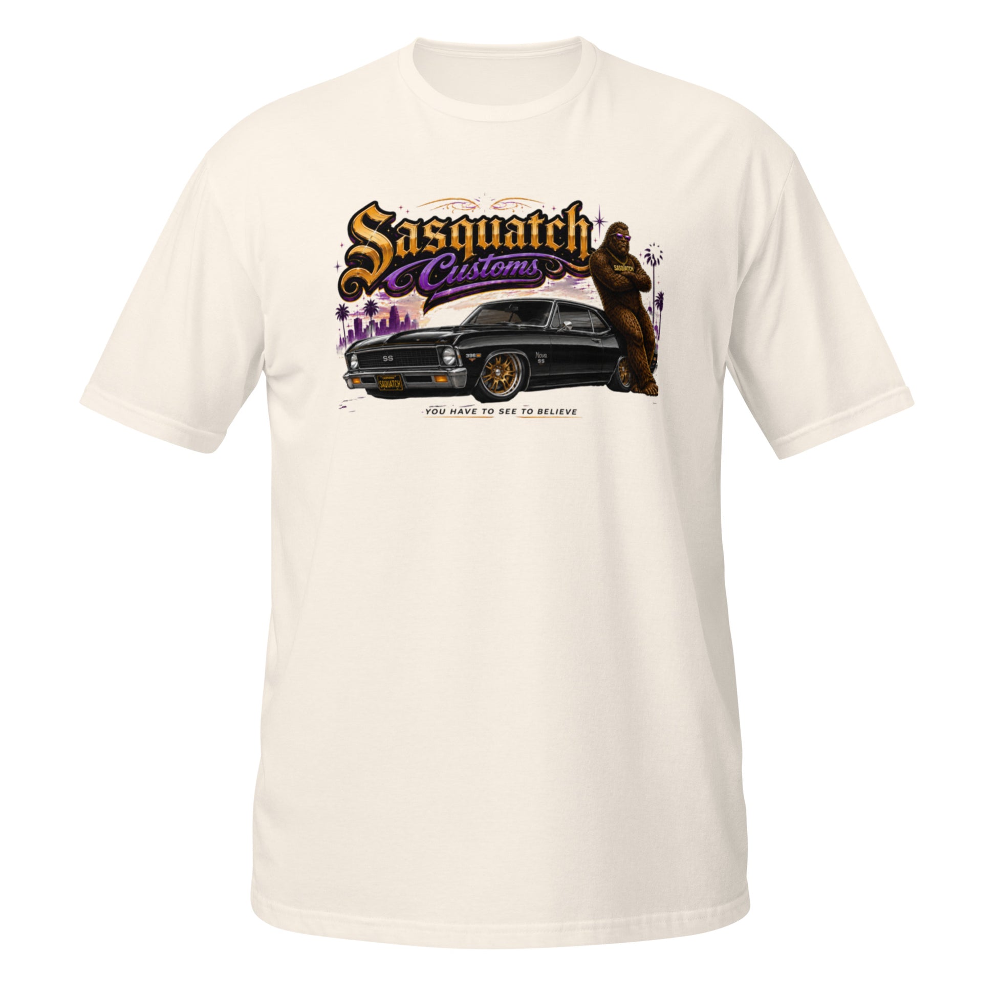 Sasquatch Customs Muscle Car Collection t-shirt — Bigfoot leaning on a black 1970 Chevy Nova pro-touring build on Forgeline billet wheels in front of a city skyline with arms crossed — funny Sasquatch muscle car tee on natural — Rod Shop Collective