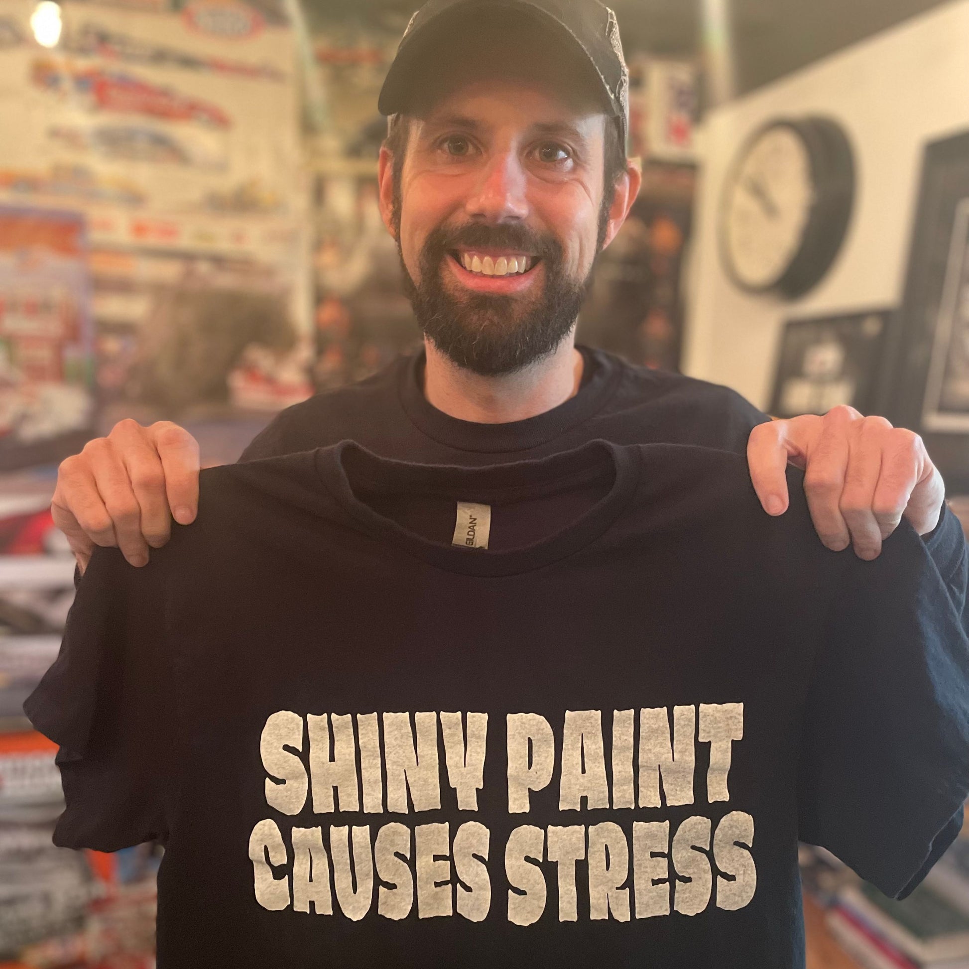 Rod Shop Collective founder holding the original hand screen printed Shiny Paint Causes Stress t-shirt — Louisville, Kentucky