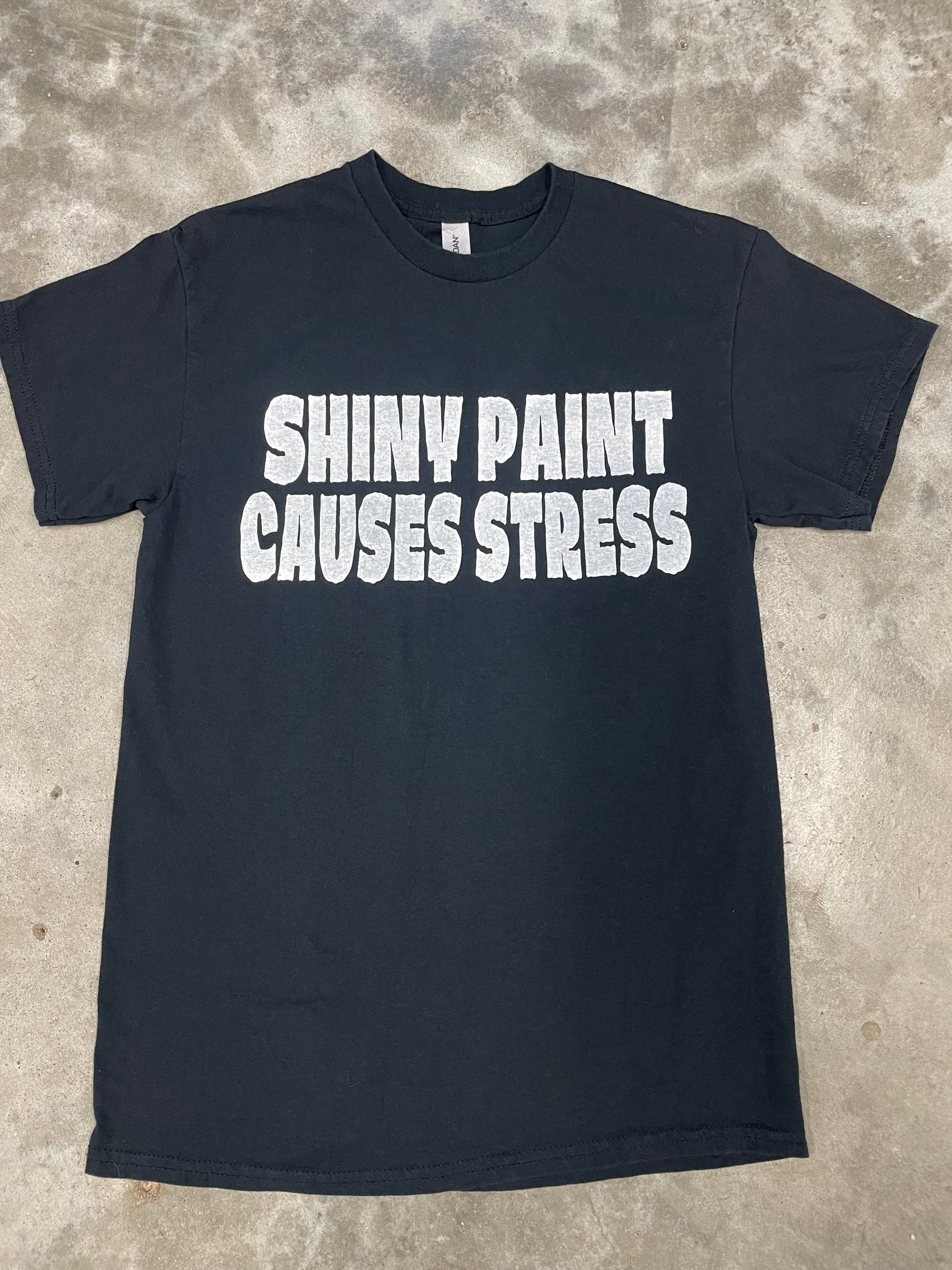 Funny car culture graphic t-shirt reading “Shiny Paint Causes Stress”